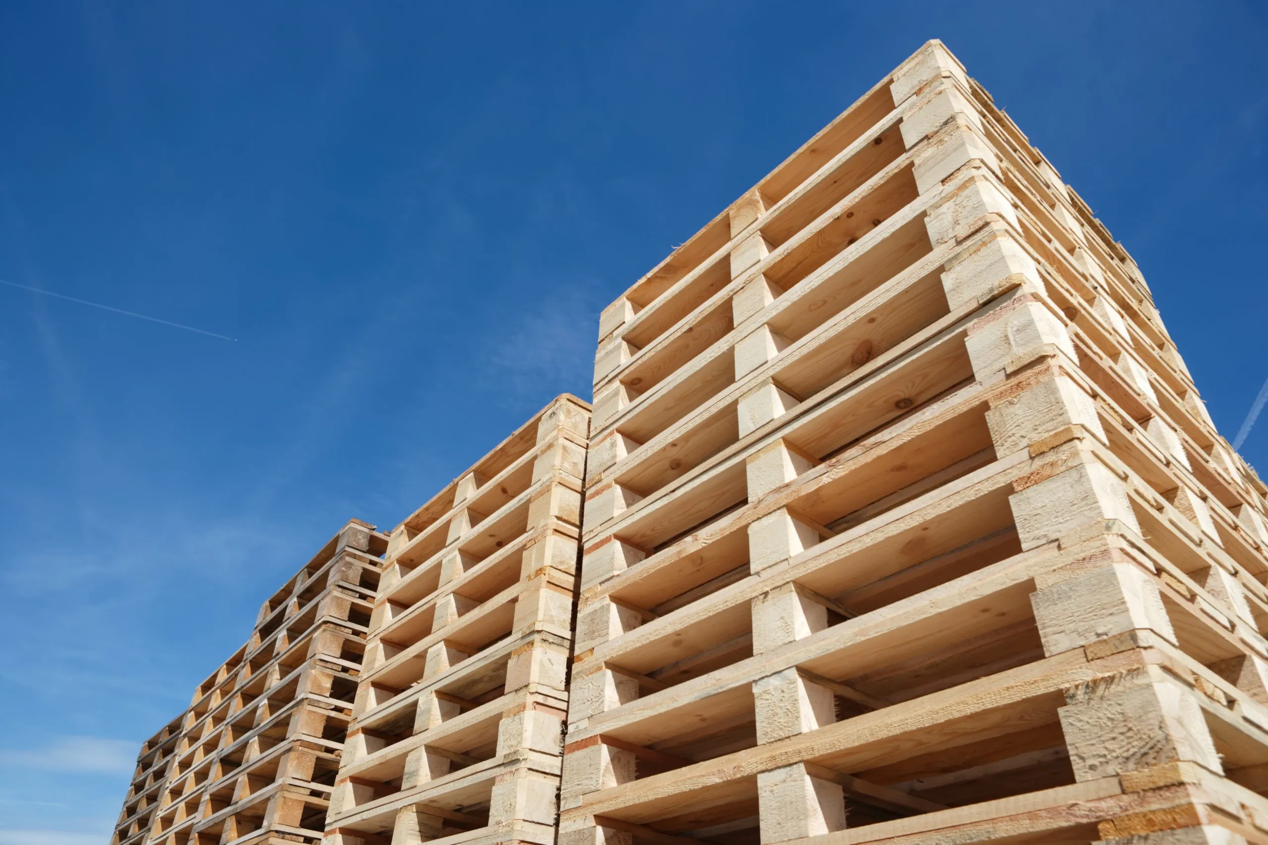 stack of wooden pallets against blue sky